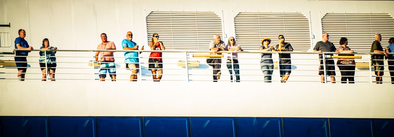 Athletes compete in a swimming competition with spectators watching from the elevated seating area at an indoor pool.