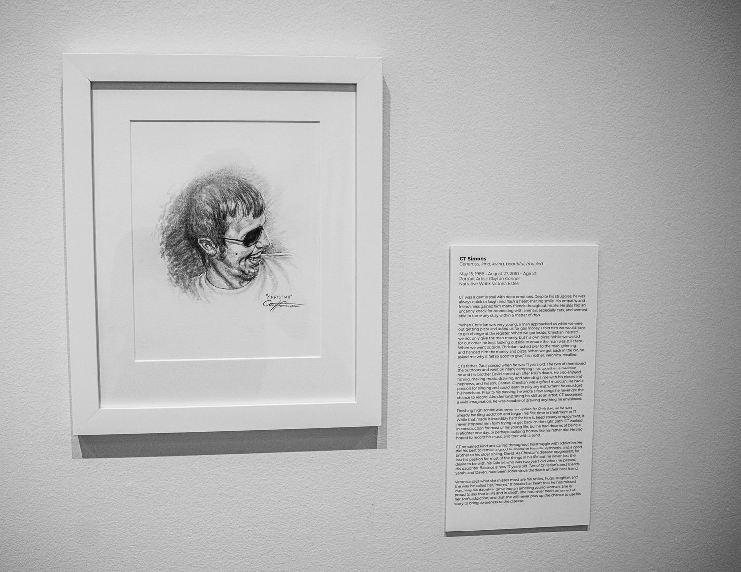 Series of mounted portrait drawings and text panels in a clean gallery setting.