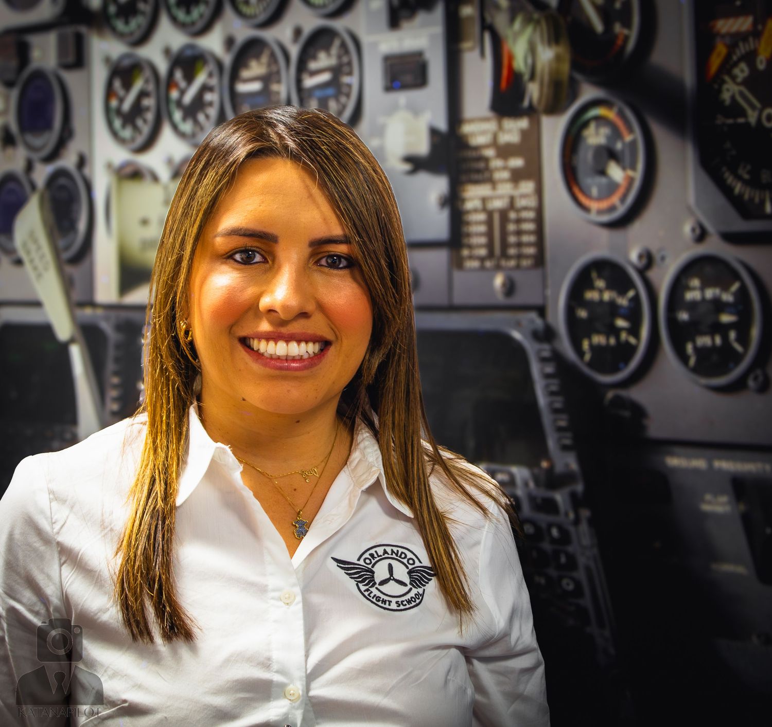 Aviation staff member in white uniform poses in front of aircraft instrument panel.