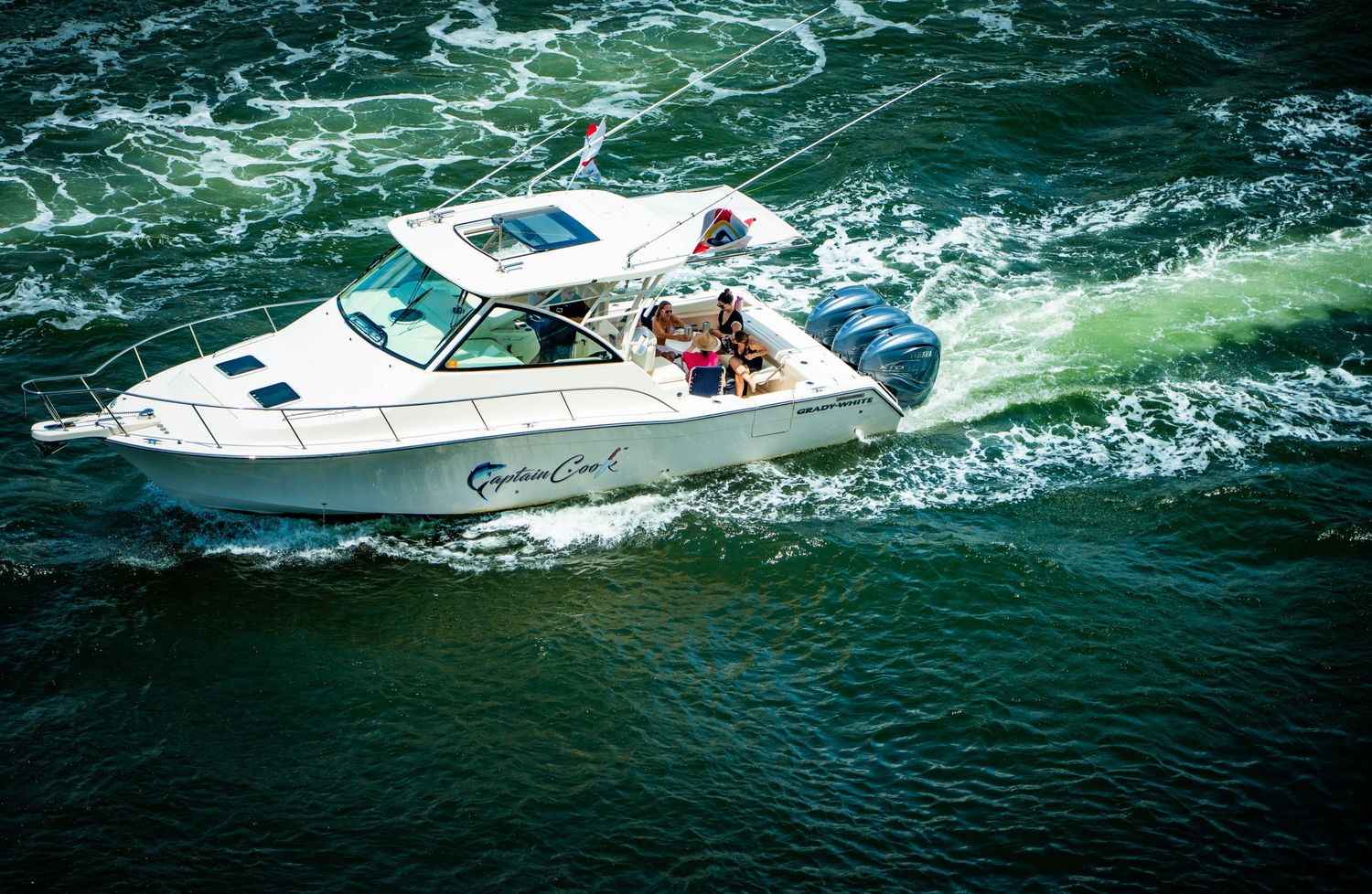 Multiple white speedboats cruising through choppy ocean waters on a sunny day.