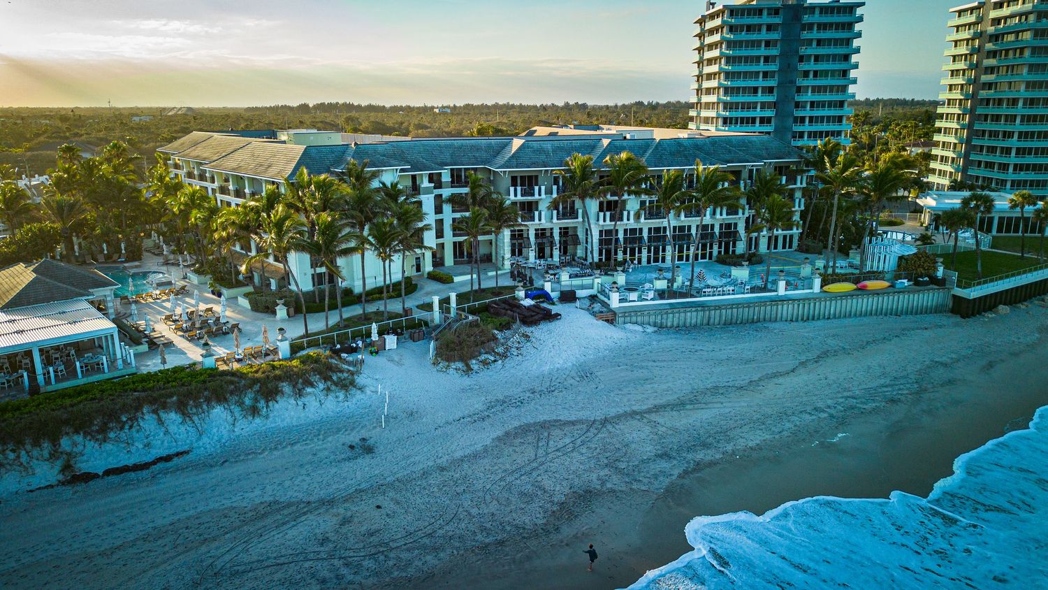 Aerial view of beachfront condominiums and resorts along a sandy coastline.