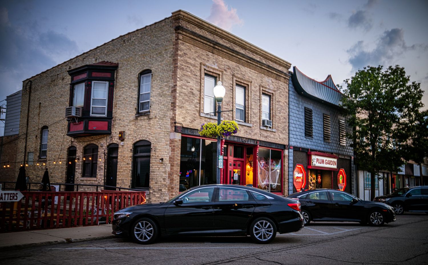 Historic brick buildings and storefronts at dusk with moody lighting.