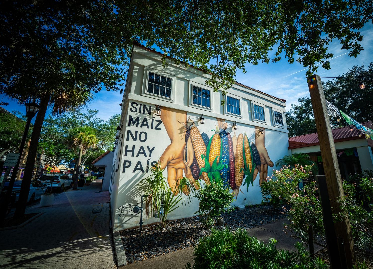 Colorful street art murals decorating exterior walls along an urban pathway.