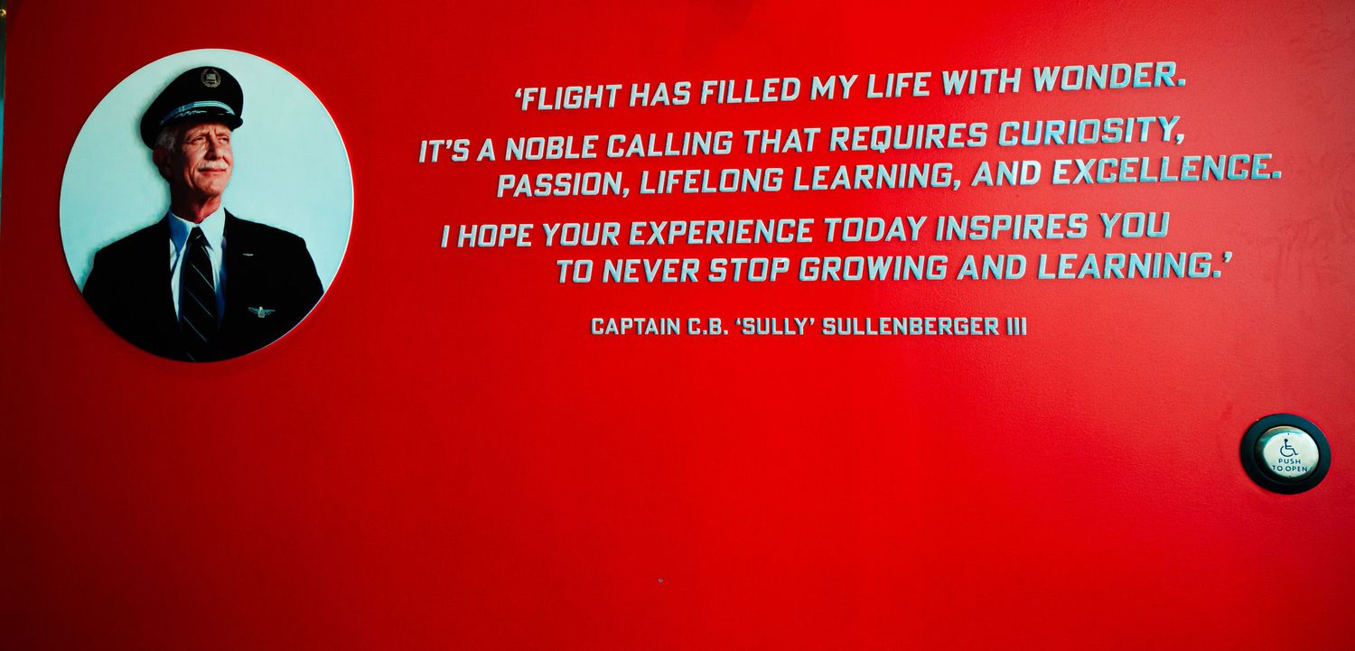 Red wall display featuring inspirational aviation quotes in white text.
