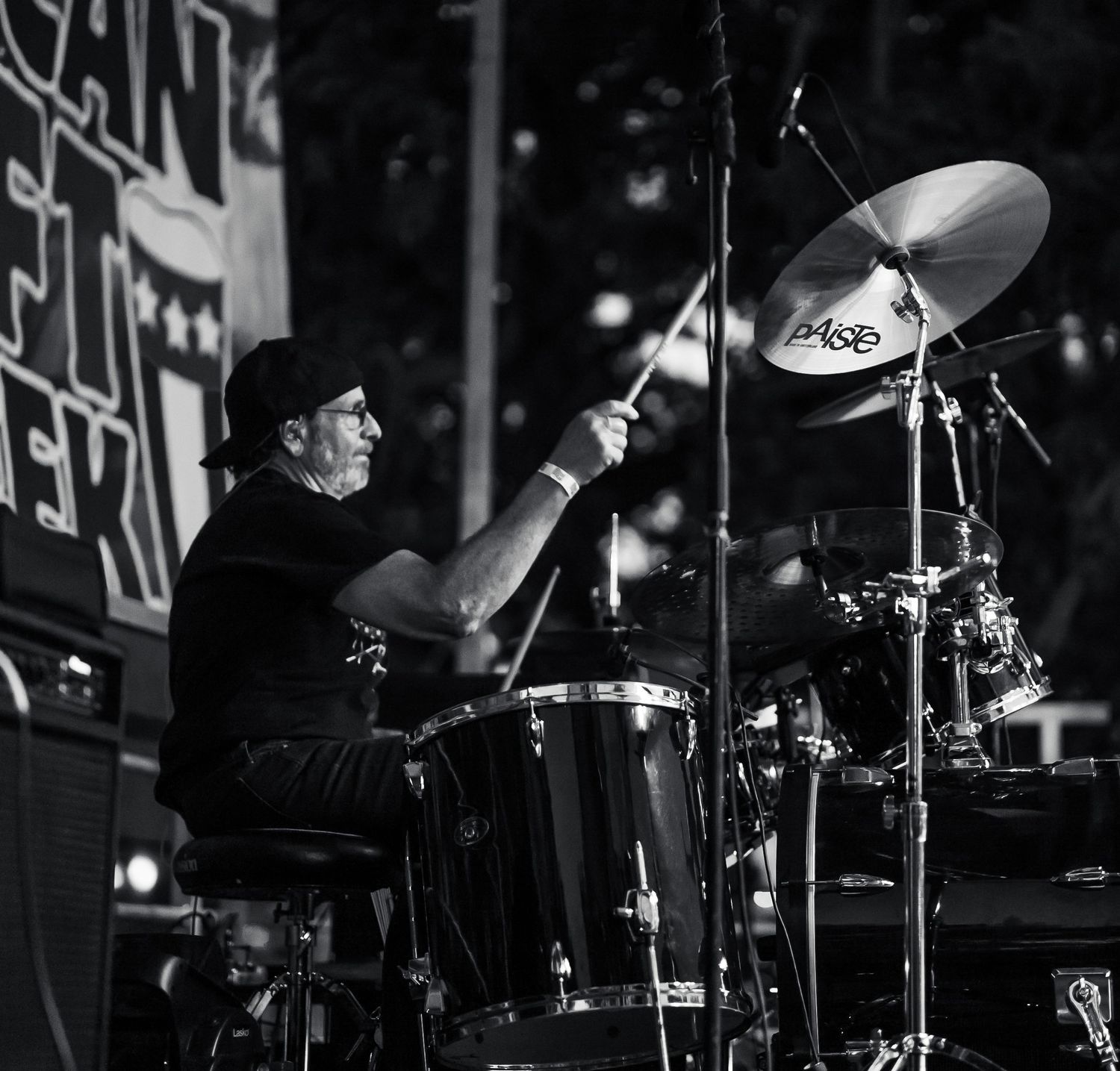 Close-up of drum cymbals and percussion equipment on a dark stage.