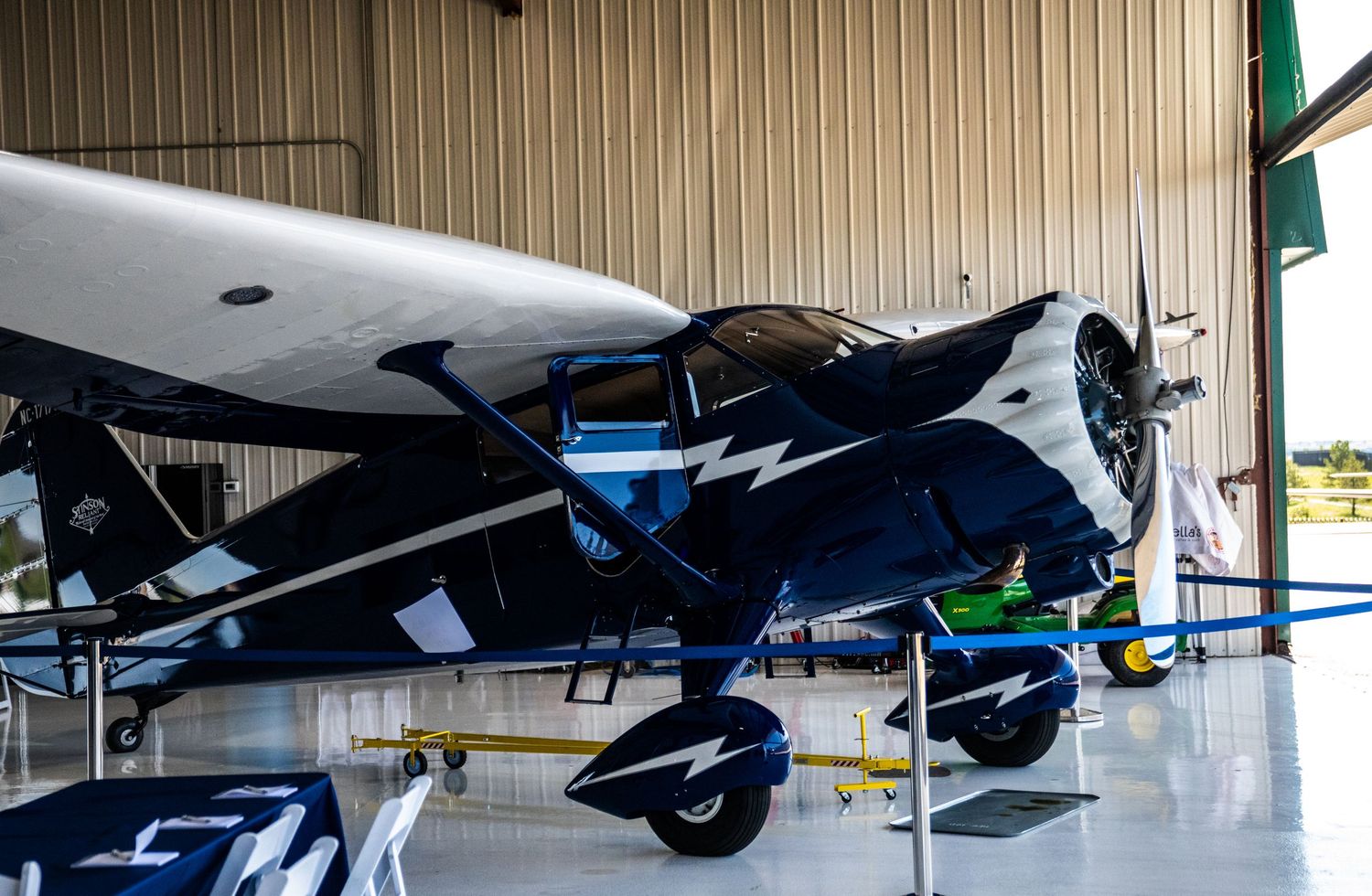 Vintage and modern aircraft displayed inside aviation hangar.