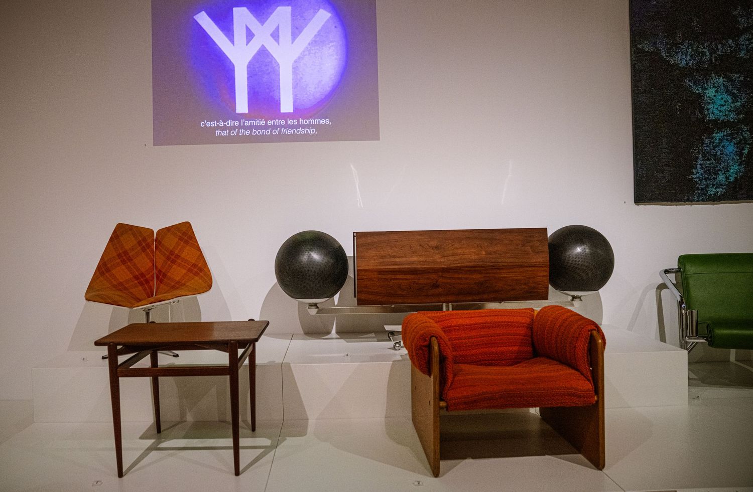 Illuminated neon signs and furniture pieces displayed in a modern gallery or showroom setting.
