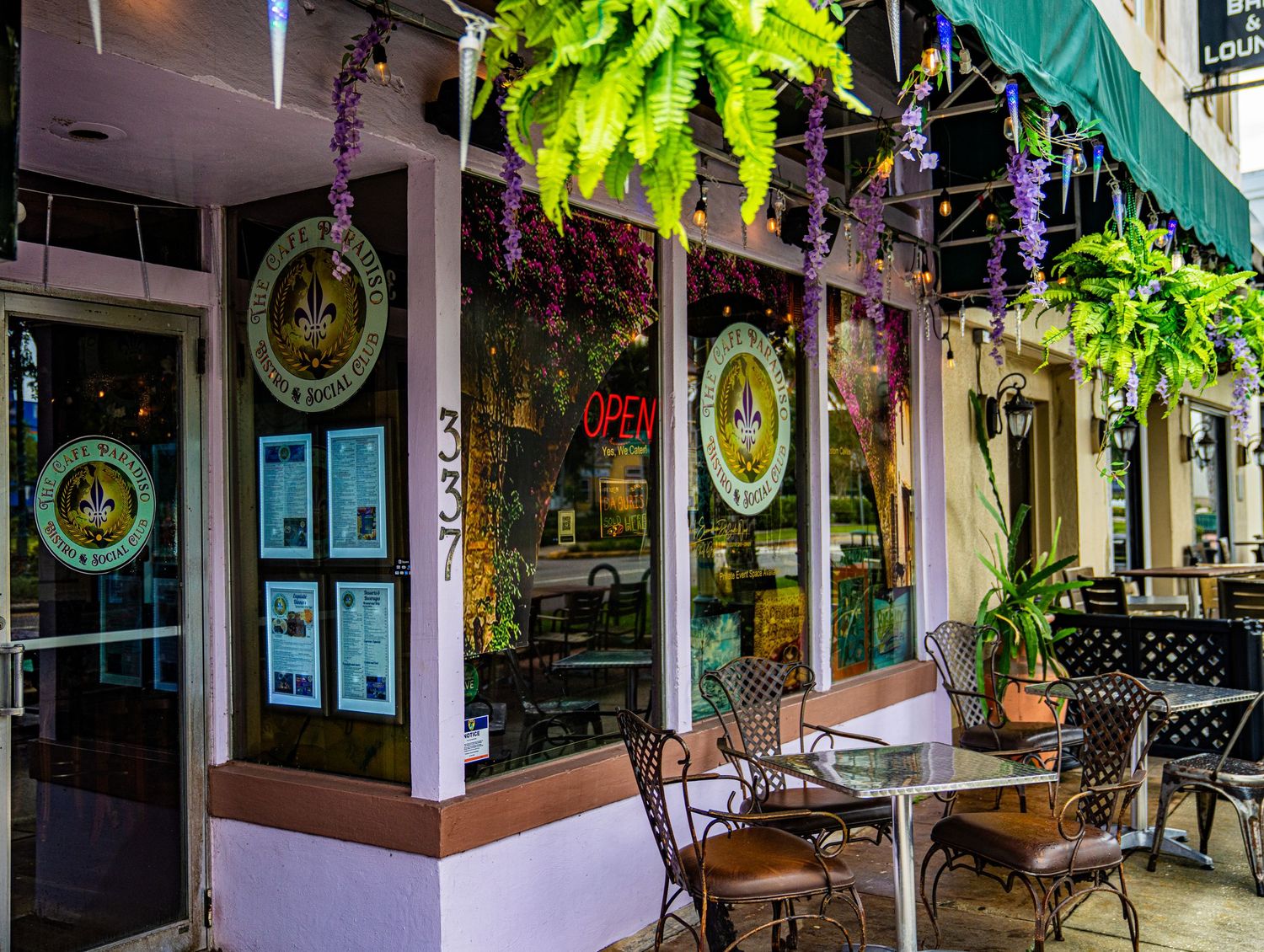 Shopping center walkway with hanging plants and decorative storefront displays.