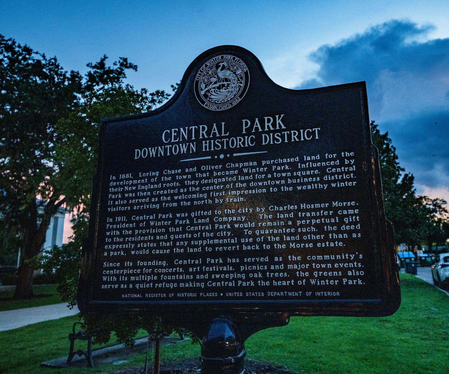 Historical marker signs for Central Park Downtown Historic District at dusk.