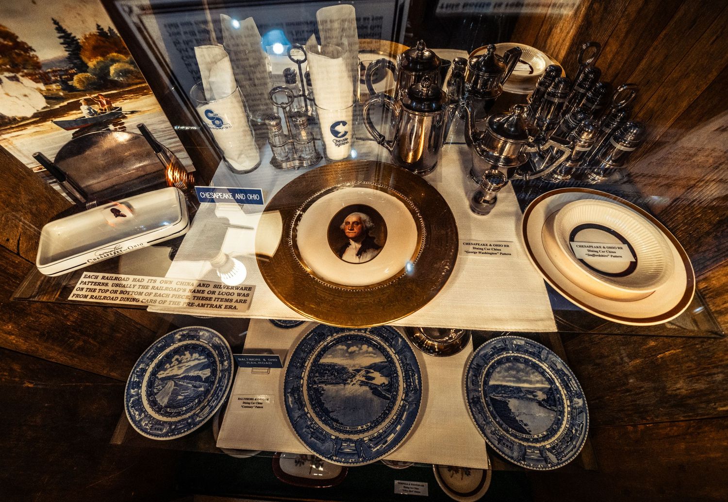 Collection of decorative blue and white plates displayed in a rustic wooden setting.