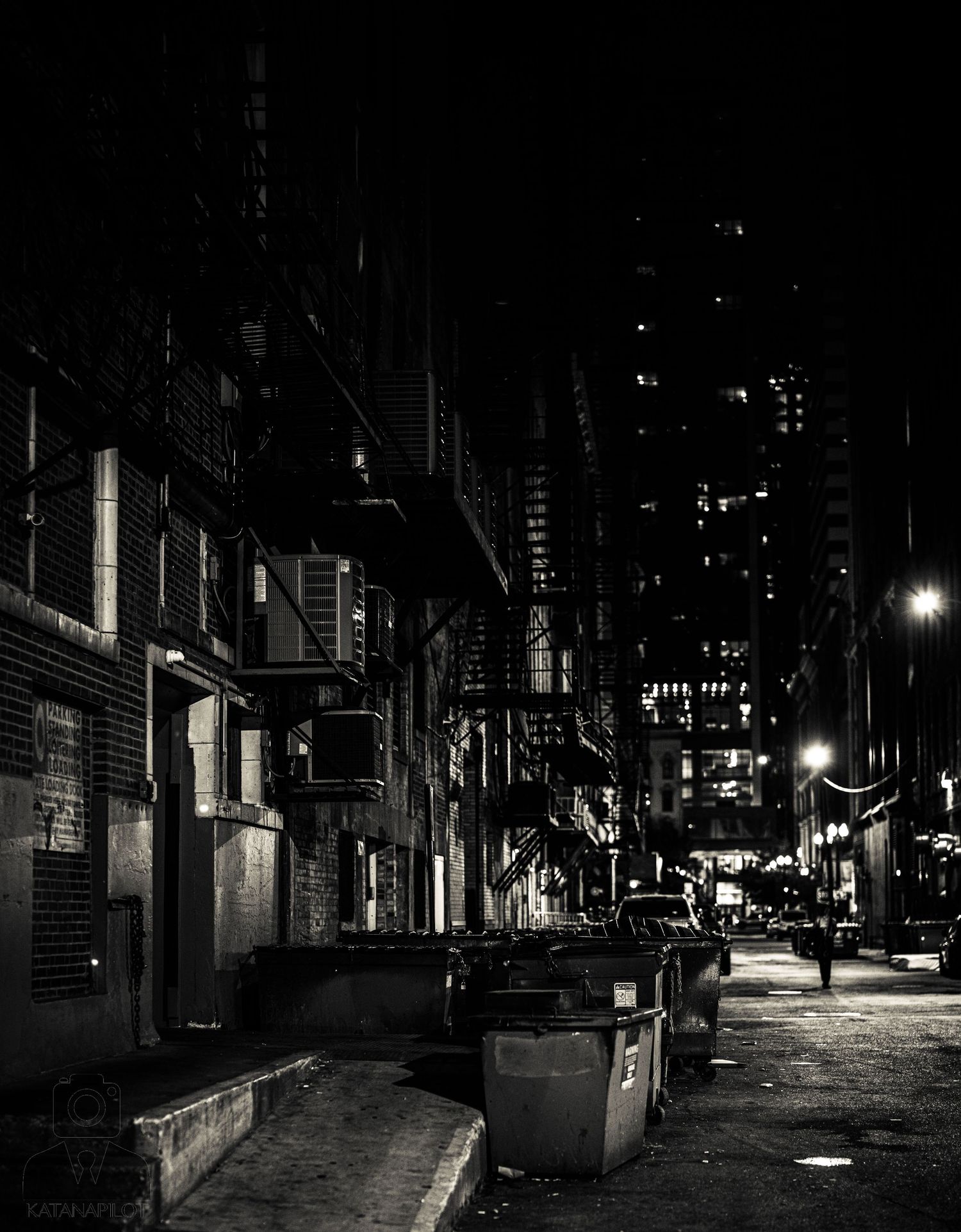 Moody nighttime cityscape with illuminated streets and buildings.