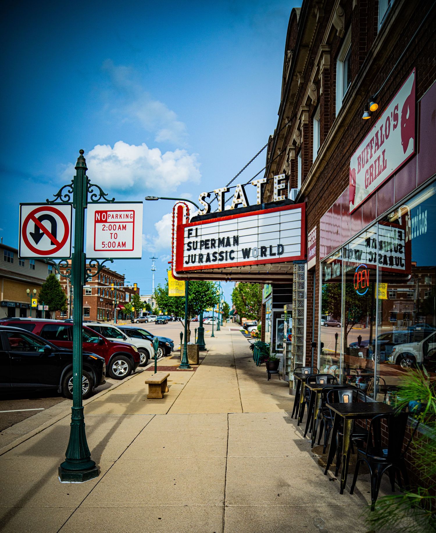 Urban streetscape with vintage lampposts, sidewalks and classic movie theater marquee.