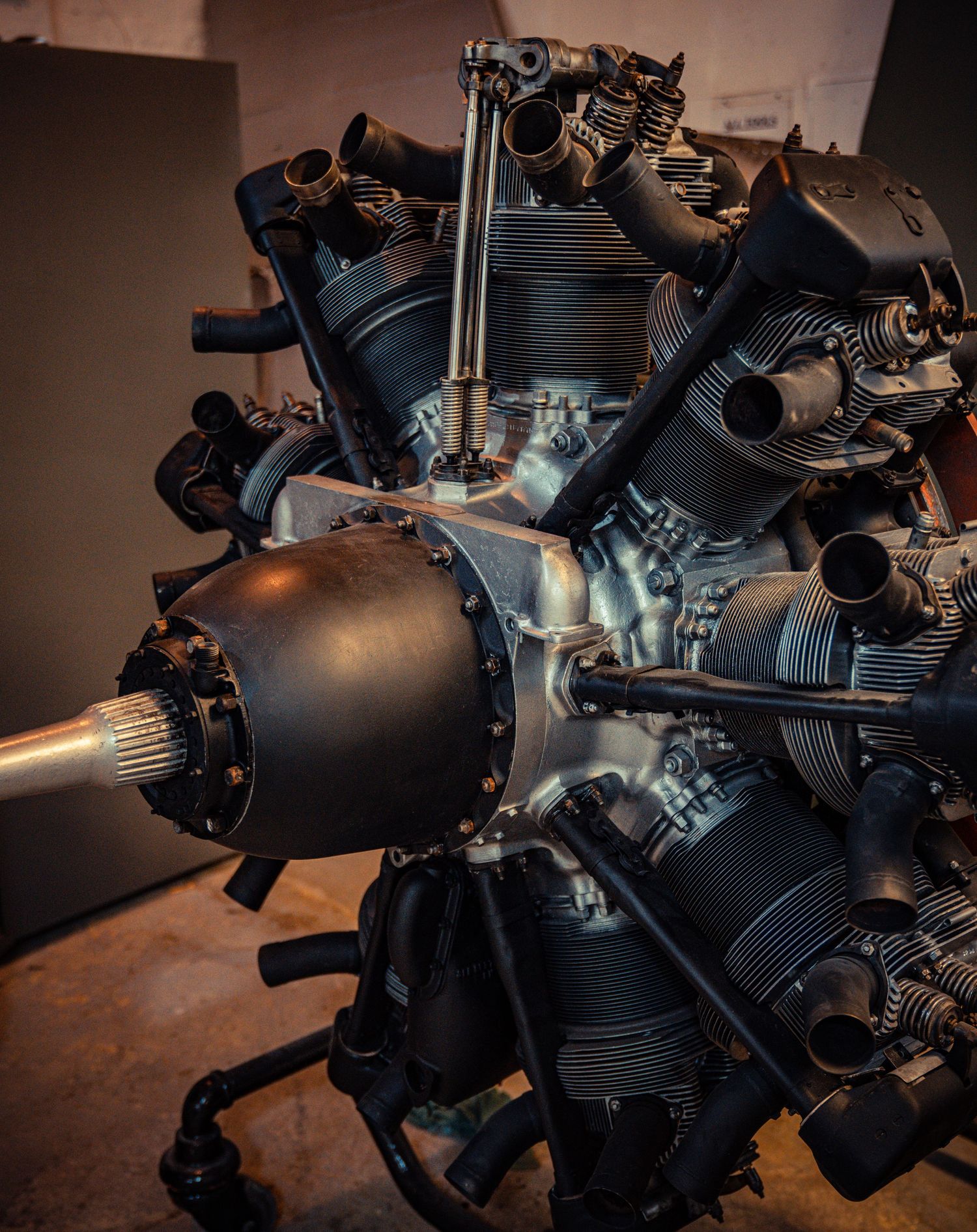 Close-up view of a vintage radial aircraft engine with black cylinders and metal components.