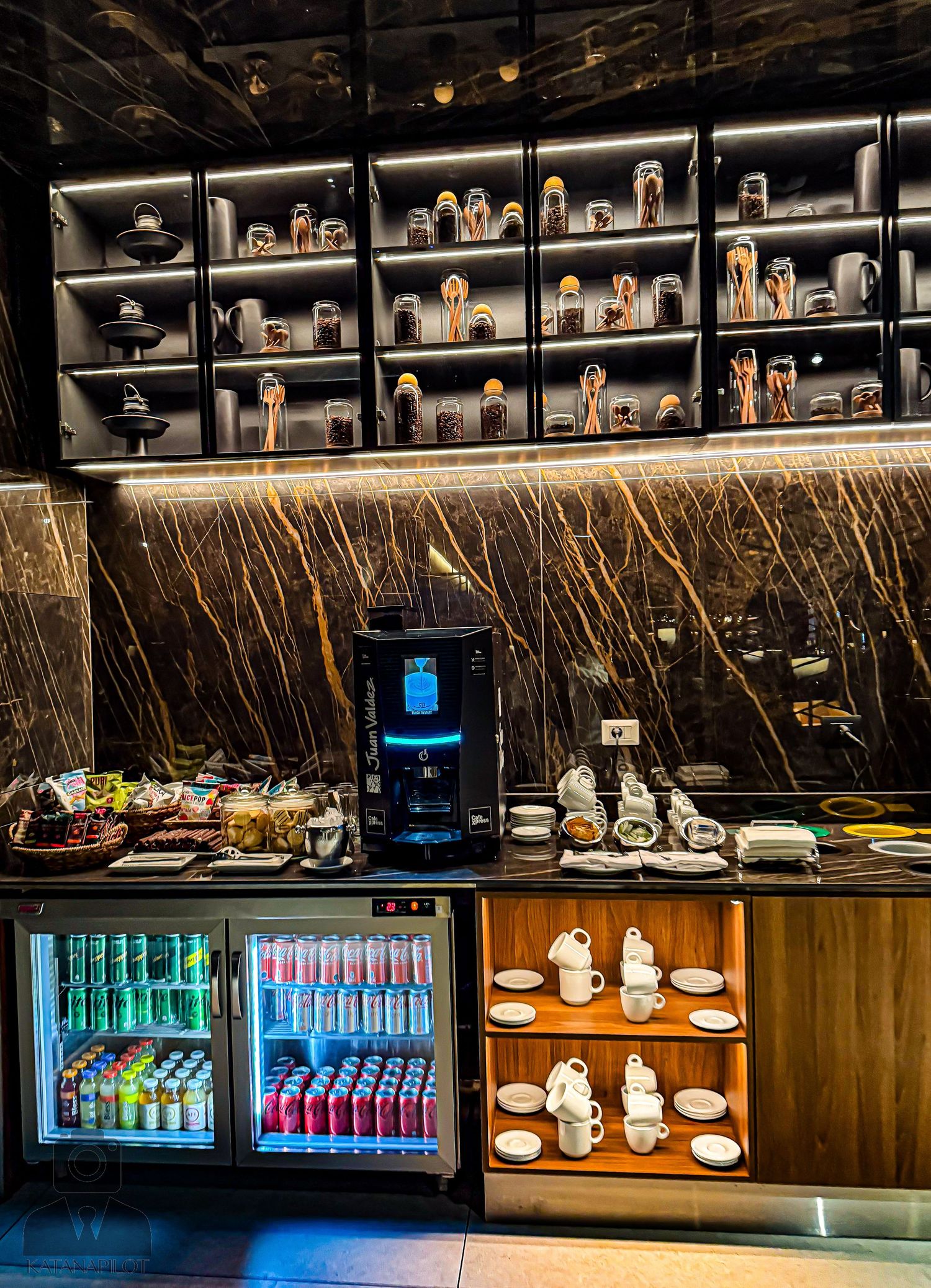 Contemporary bar counter with illuminated shelving and beverage displays.