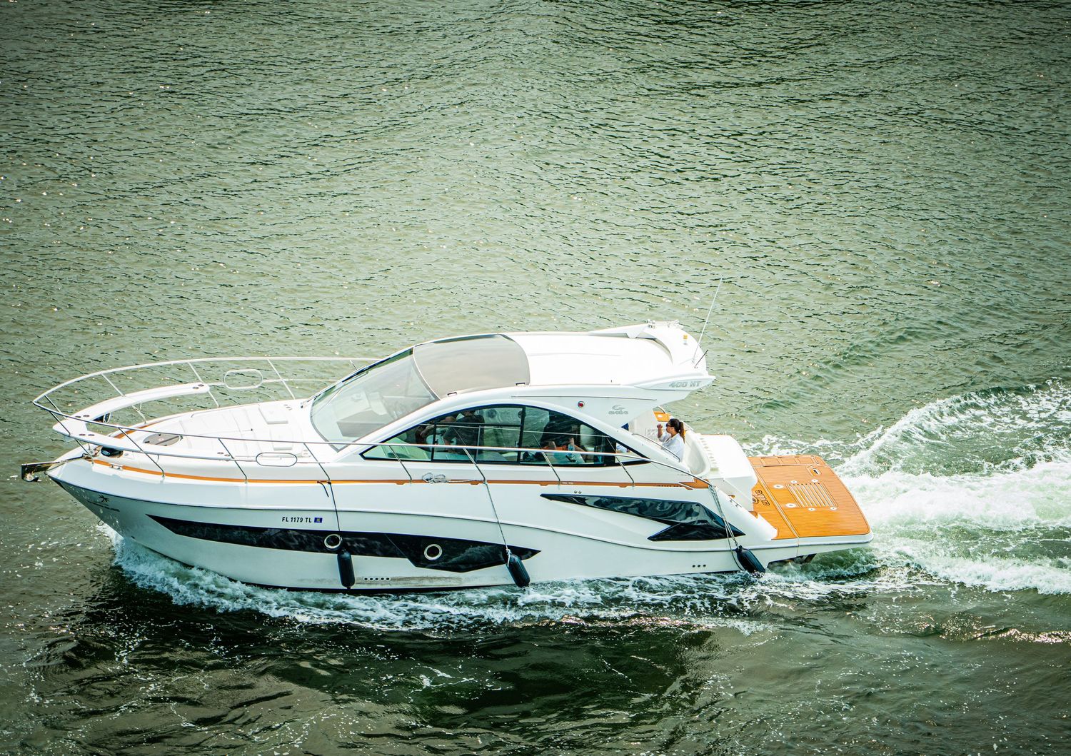 Luxury yachts and speedboats navigating through dark green waters.