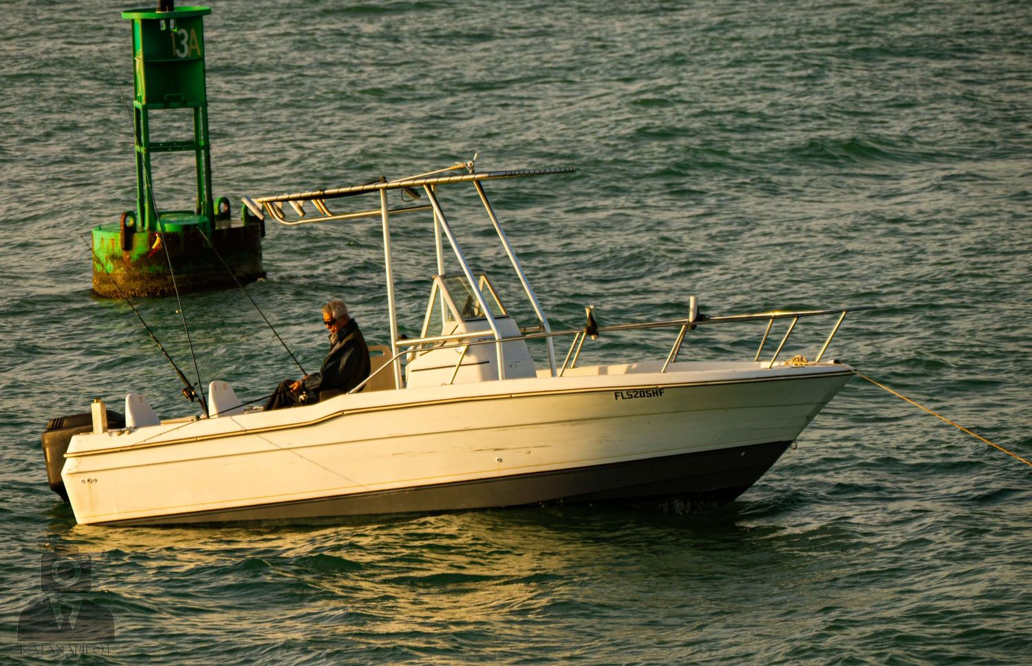 A sequence of fishing boats moving across dark waters with fishing gear and equipment visible on their decks.