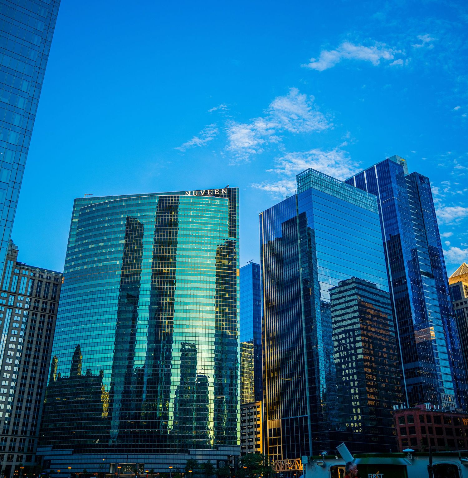 Panoramic view of glass office buildings in Chicago's business district with blue sky backdrop.