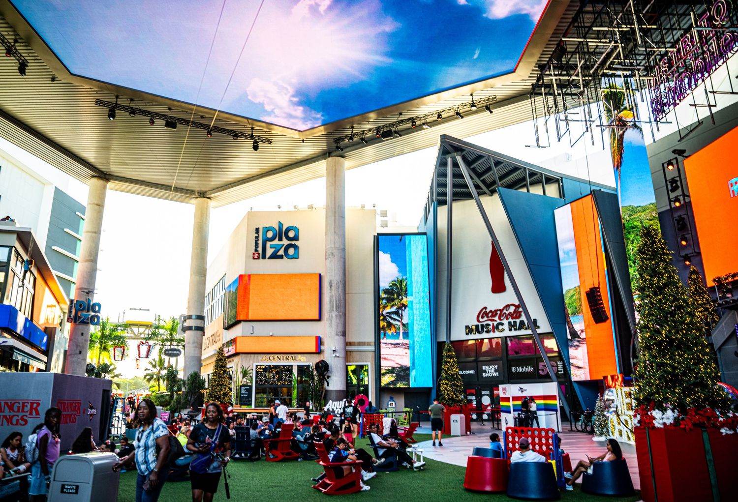 A panoramic view of a colorful indoor event space with modern architecture and scattered seating areas.