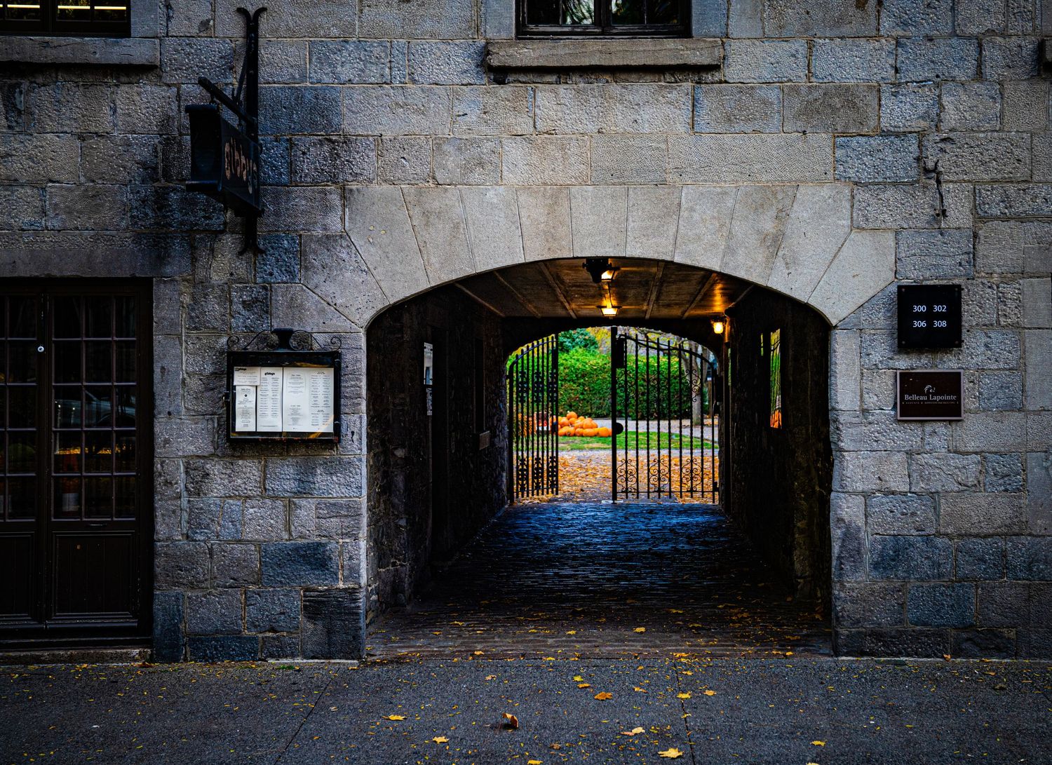 Row of stone archways and basement windows along an old building's foundation.