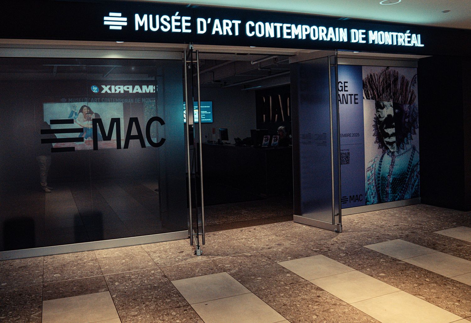 Illuminated entrance sign for the Museum of Contemporary Art Montreal at night.