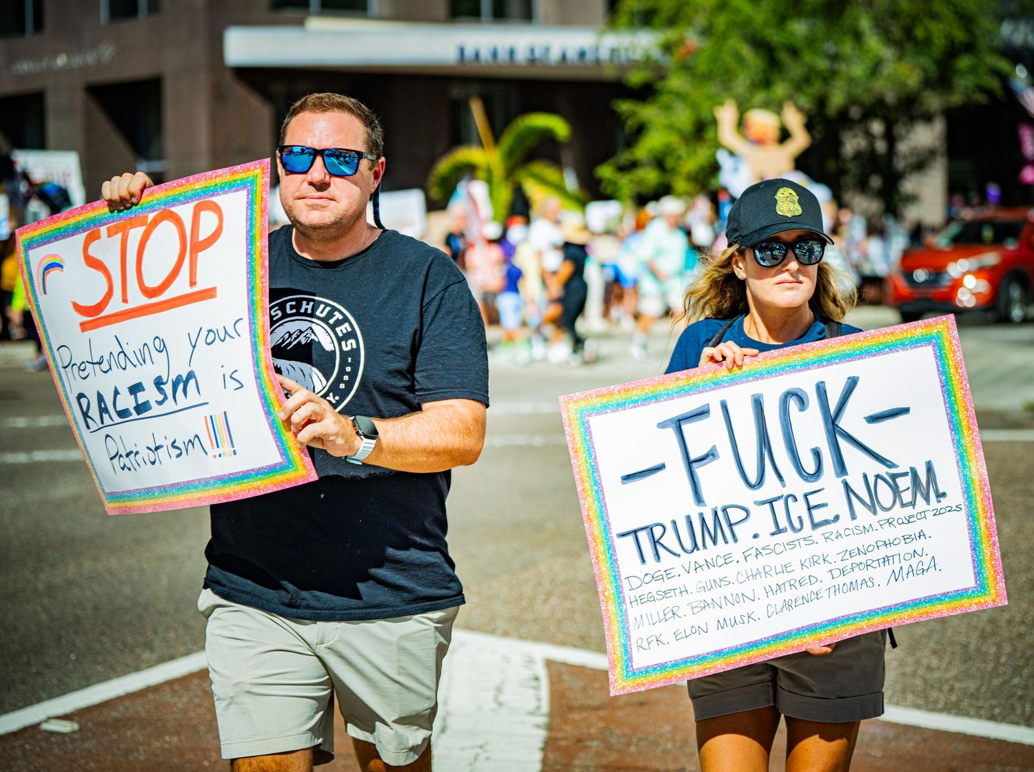 Row of protest signs displayed along a sunny street during a demonstration.