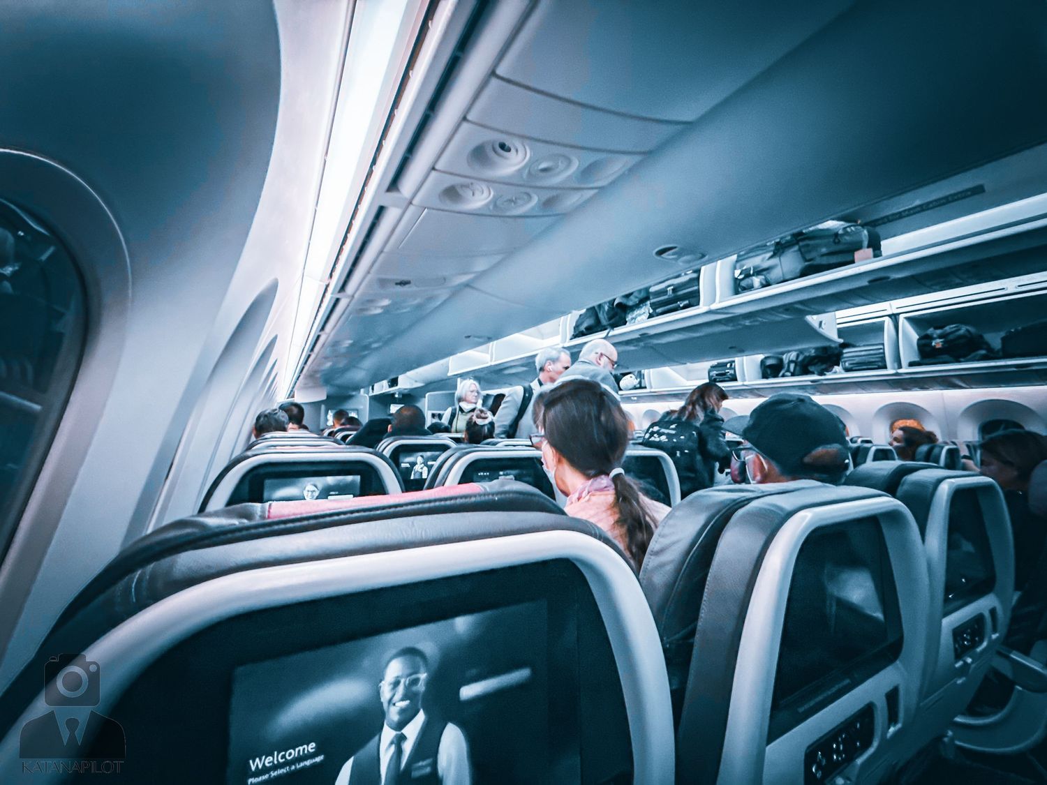 Interior view of commercial airplane cabin with overhead storage compartments.