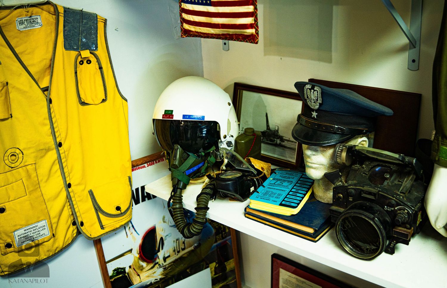 Shelf displaying yellow aviation safety equipment and technical gear.