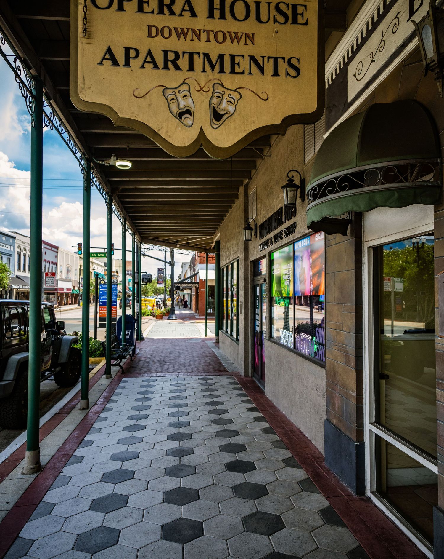 Covered walkway with hexagonal tile flooring outside the Opera House Apartments building.