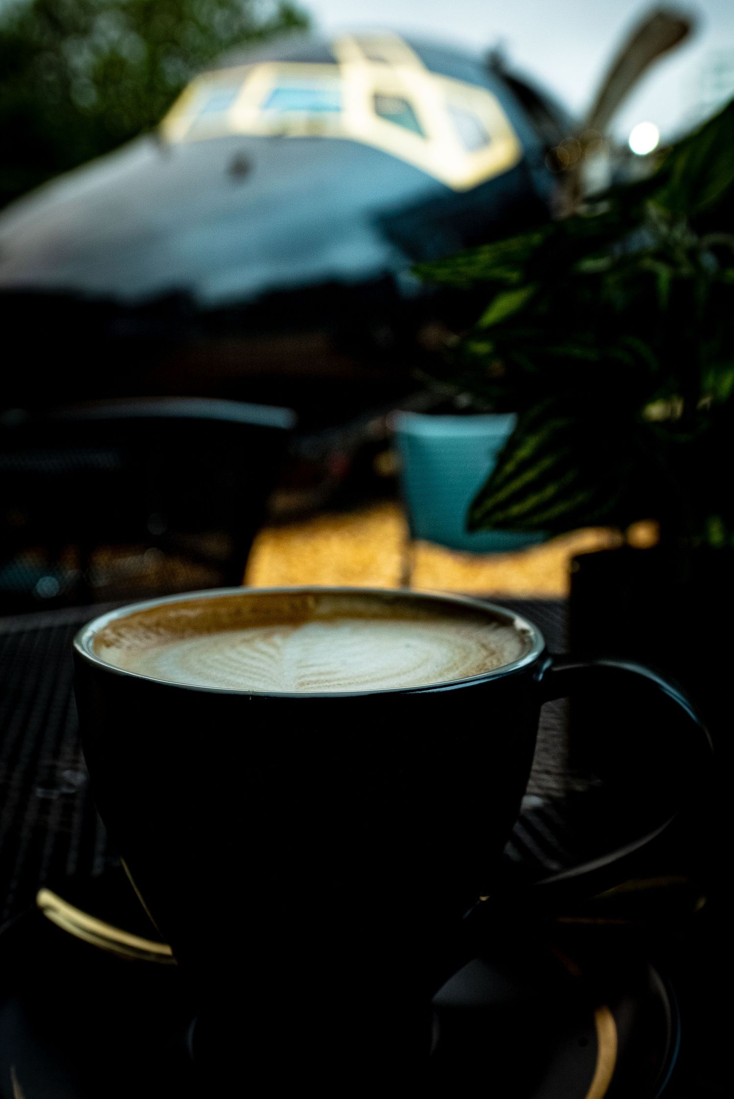 Close-up of latte art in black coffee cups with natural lighting.