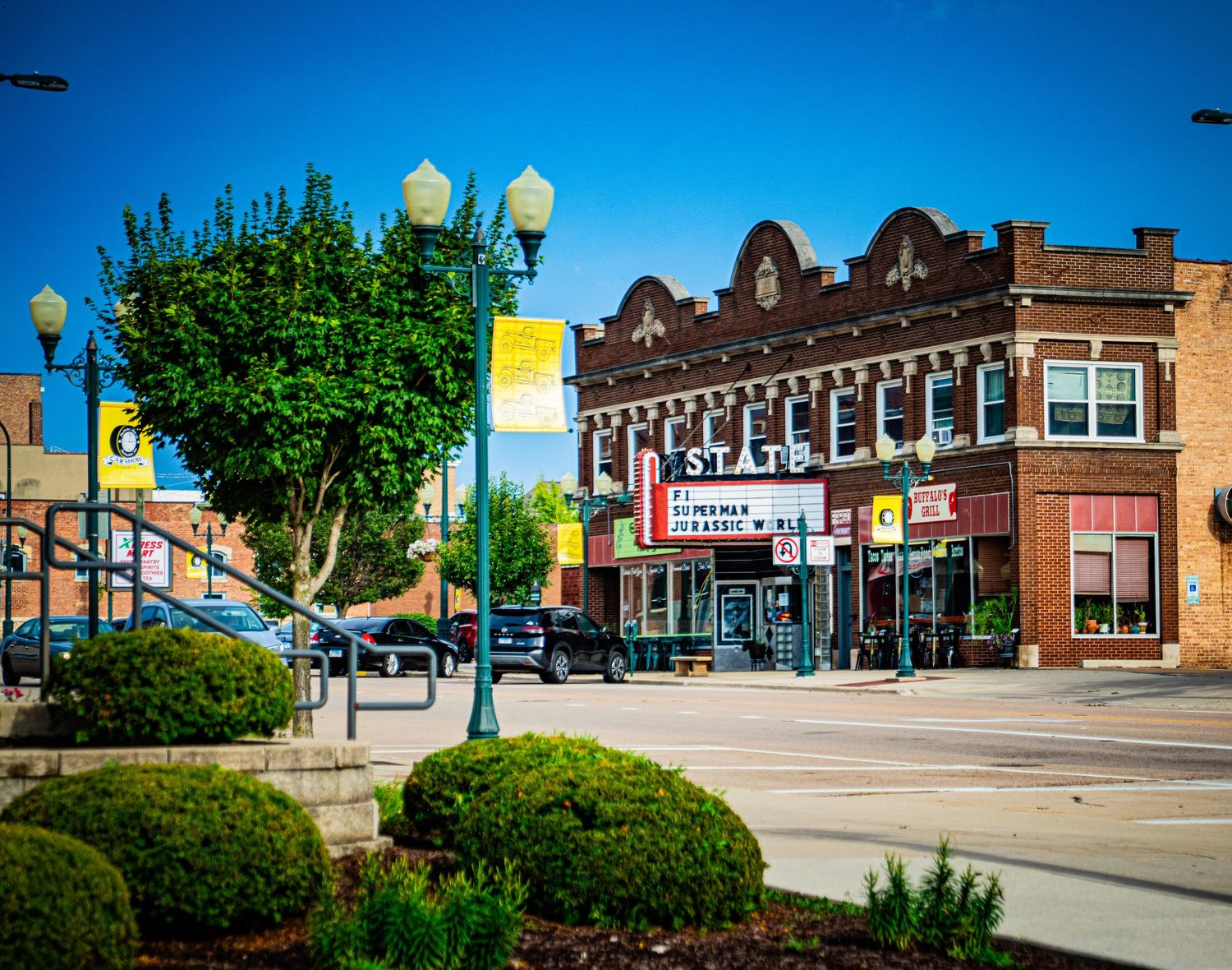 Downtown street view showing brick commercial buildings and storefronts in a small Midwestern town.