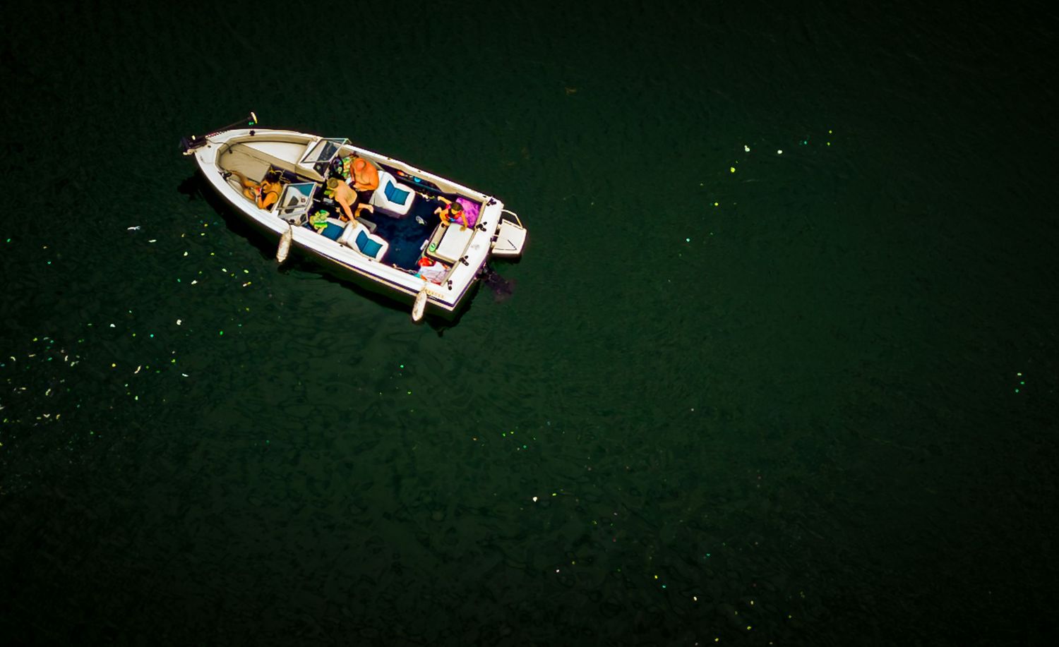 Small boats docked in a marina with emerald green water.