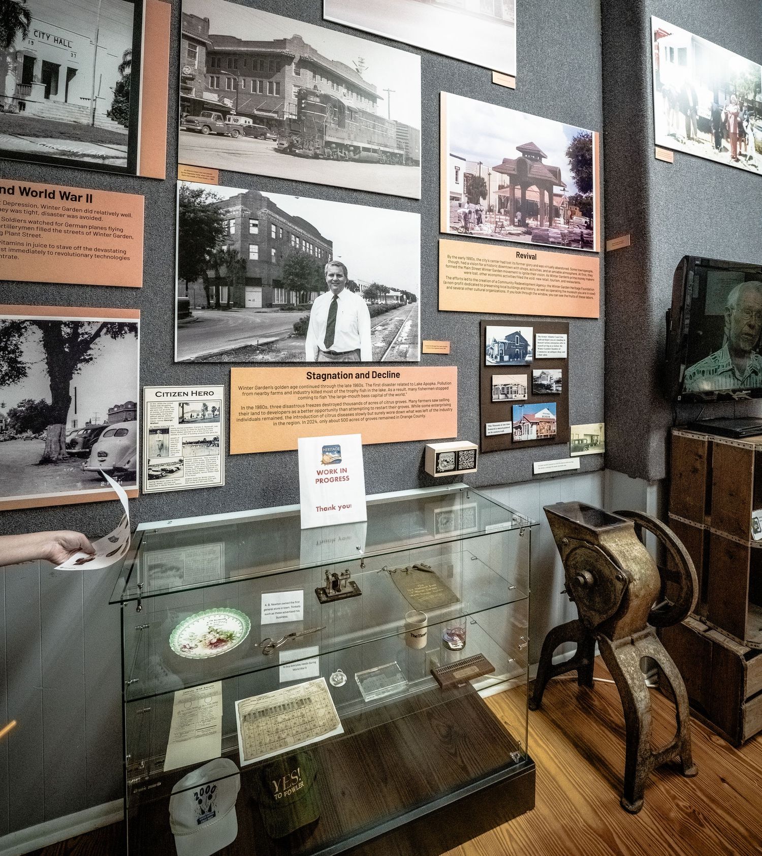 Display cases with historical artifacts and photographs in a museum exhibition.