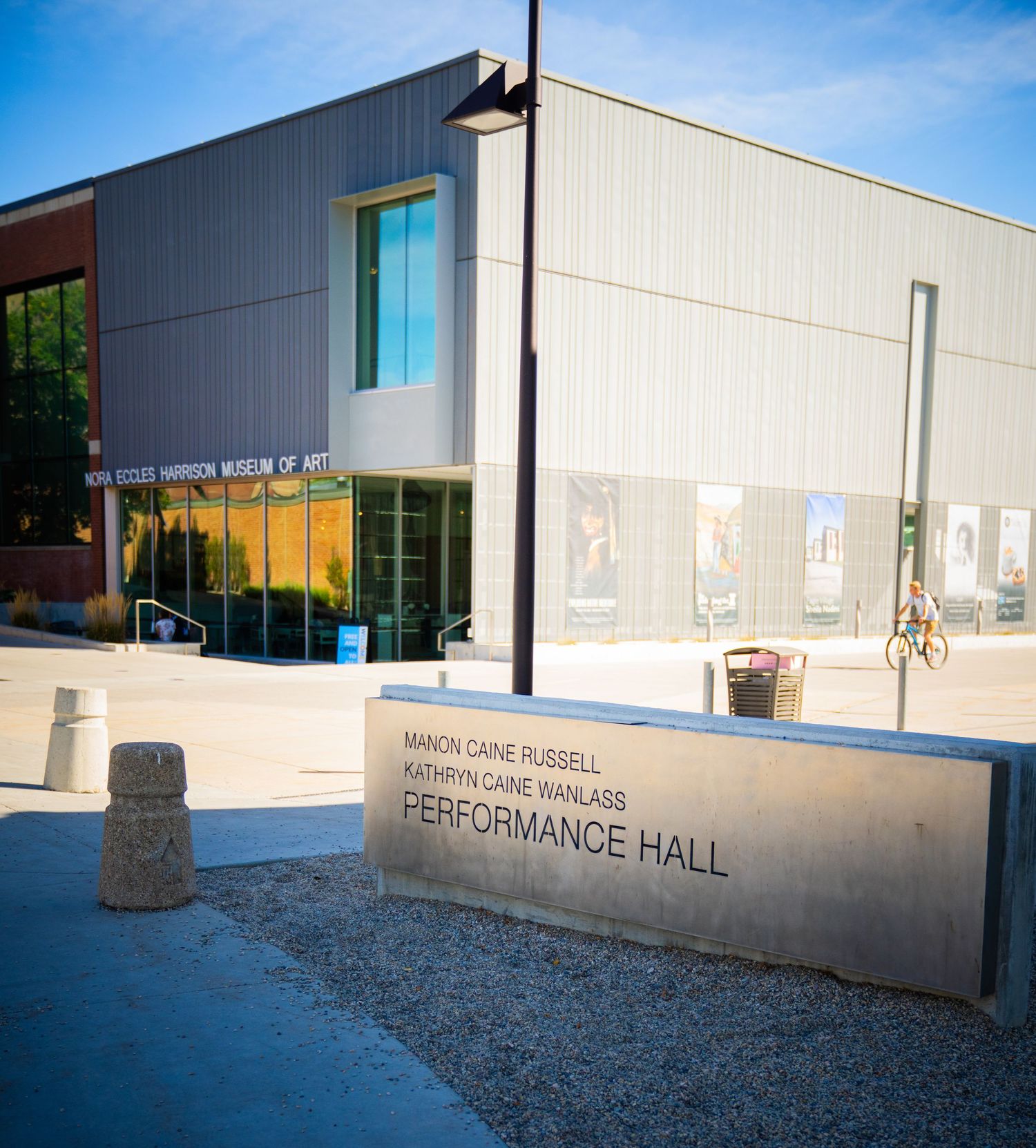Exterior view of a modern performance hall building with white walls under blue sky.