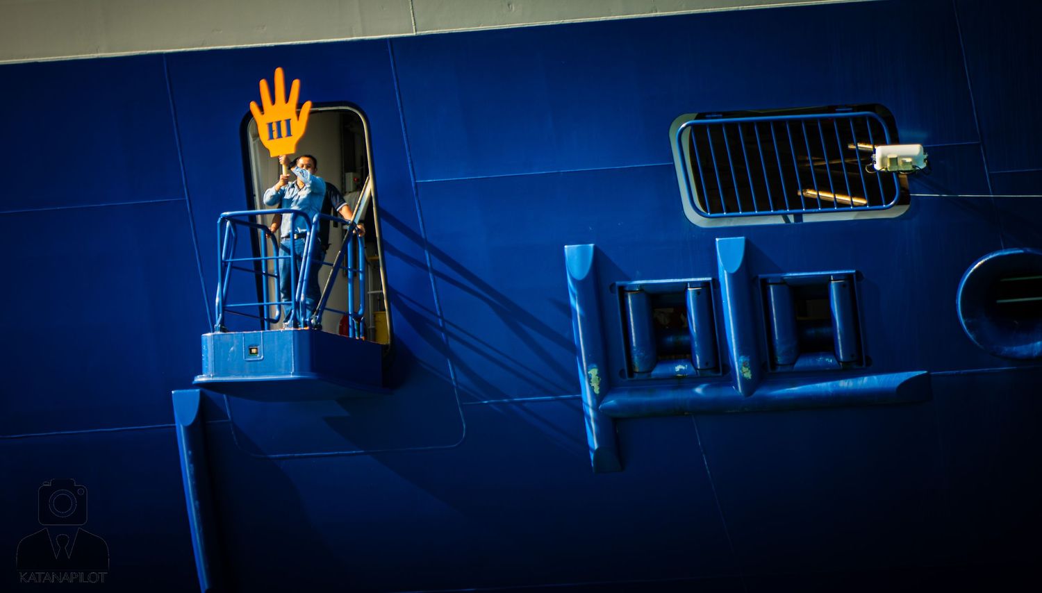Blue-lit carnival ride control panels and operator stations glowing in the dark at an amusement park.