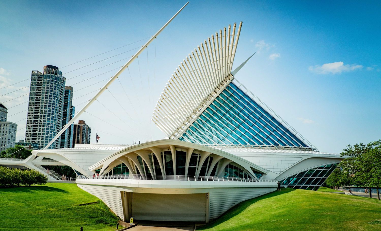 Modern architectural structure with white geometric design against bright blue sky.
