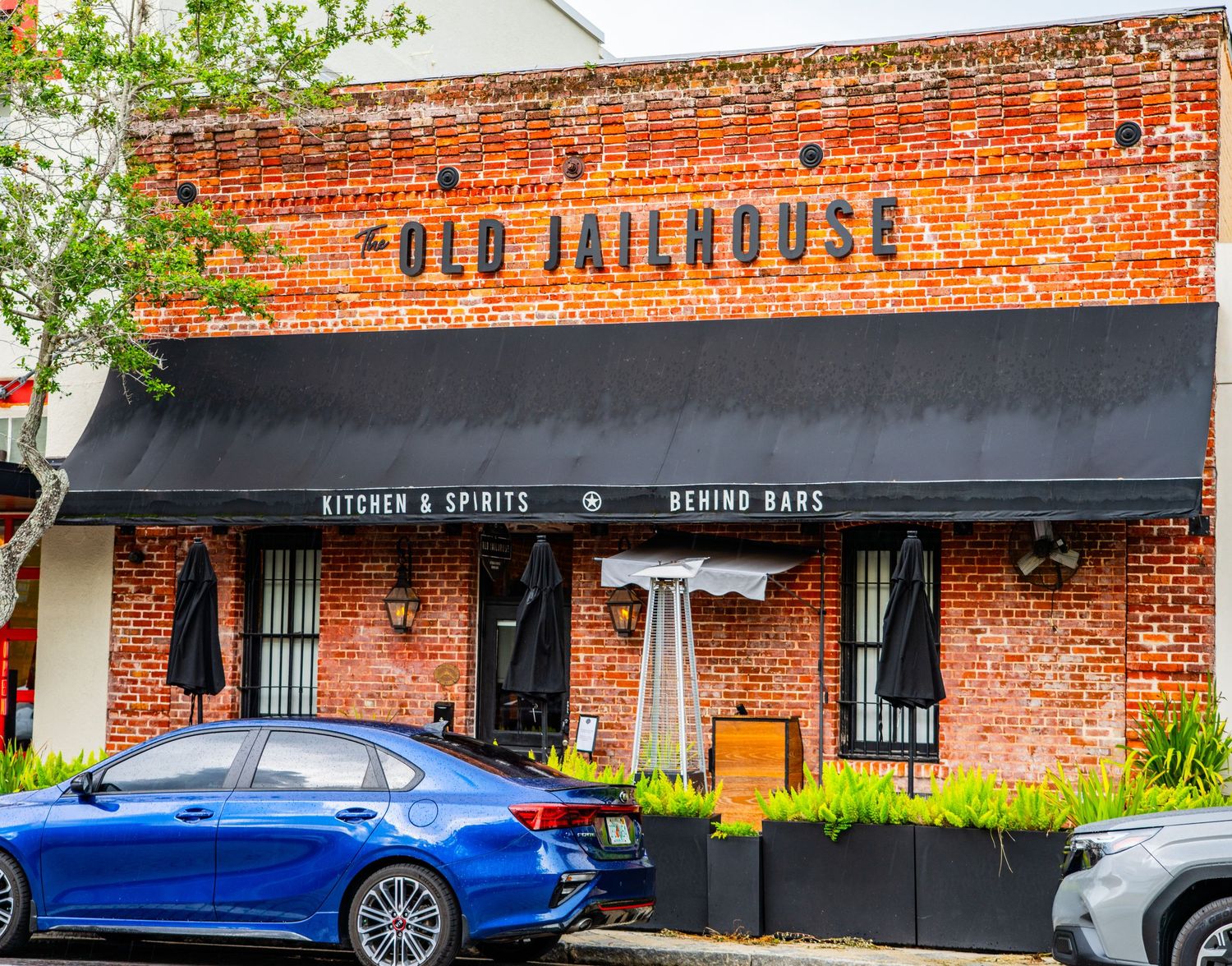 Vintage brick building with 'Old Jailhouse' signage and black awning on historic storefront.