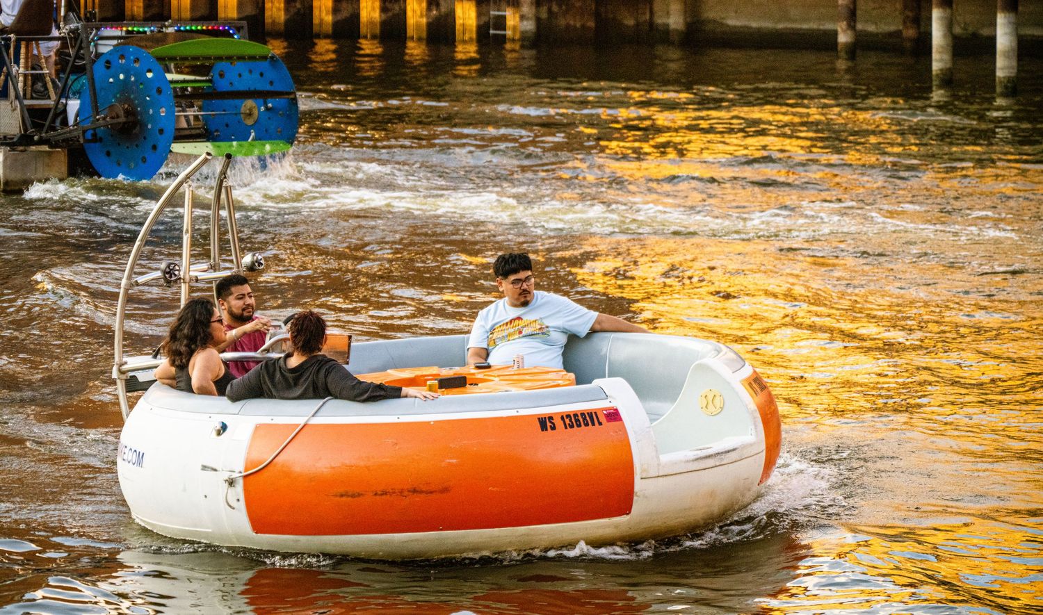 Recreational boats floating on golden sunlit waters of the Chicago River.