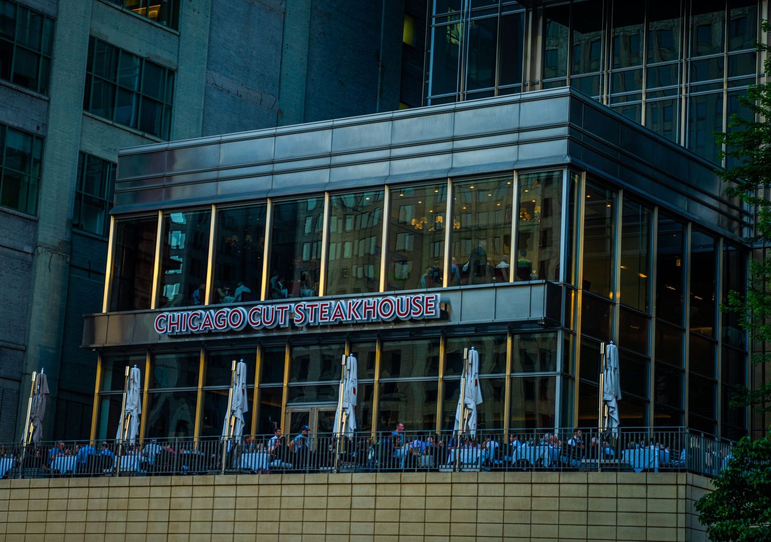 Modern glass building entrance with outdoor seating area in downtown Chicago.