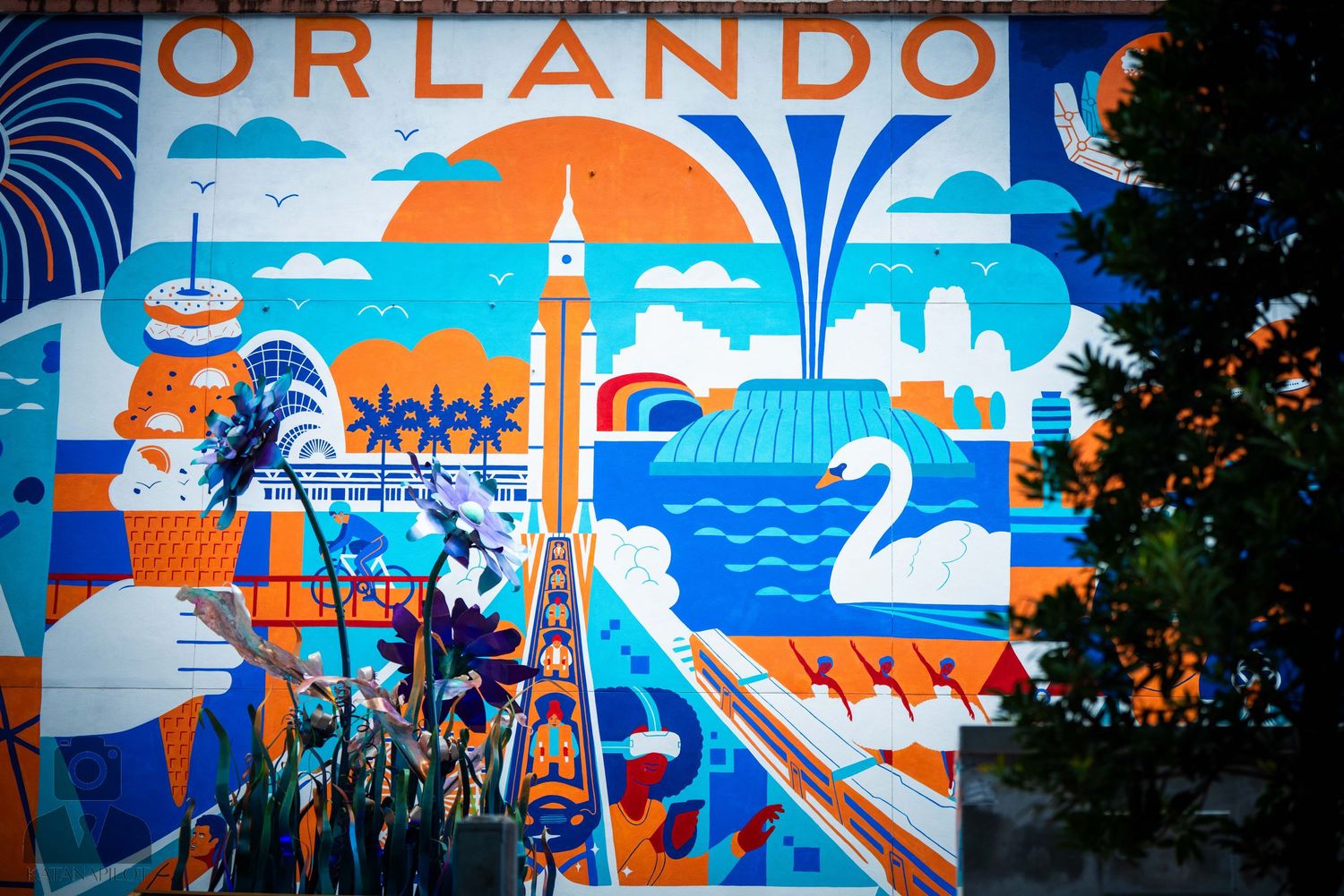 Colorful mural featuring Orlando skyline with vibrant orange and blue artwork spanning multiple panels.
