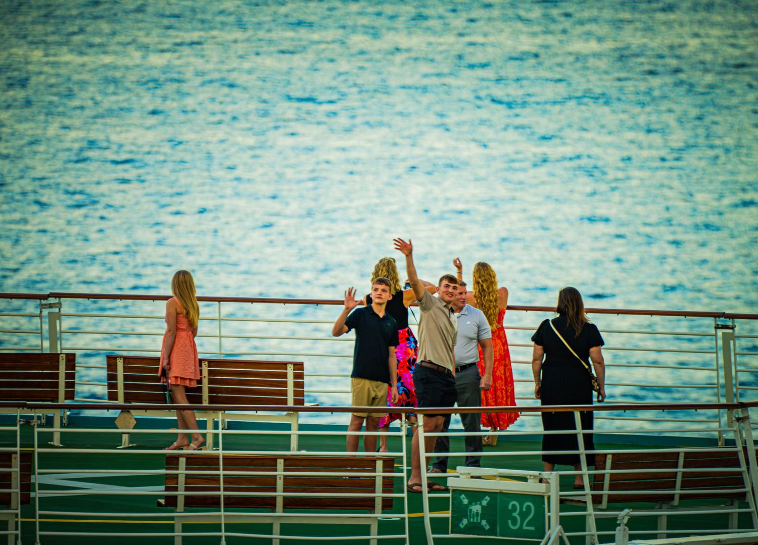 A sequence of figures seated on green bleachers against a blue-tinted background.