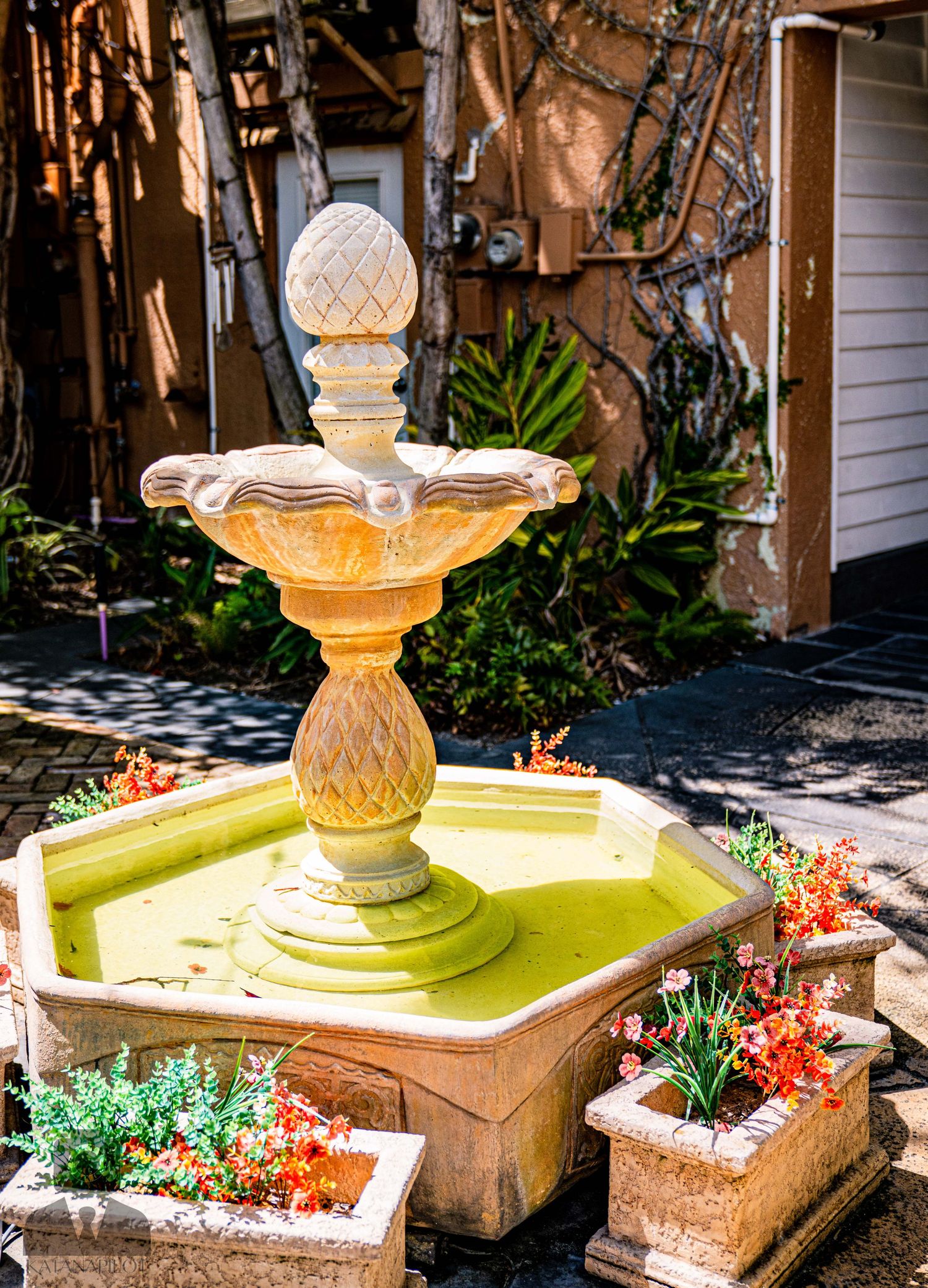 Decorative stone finials with ornate details in a garden setting.
