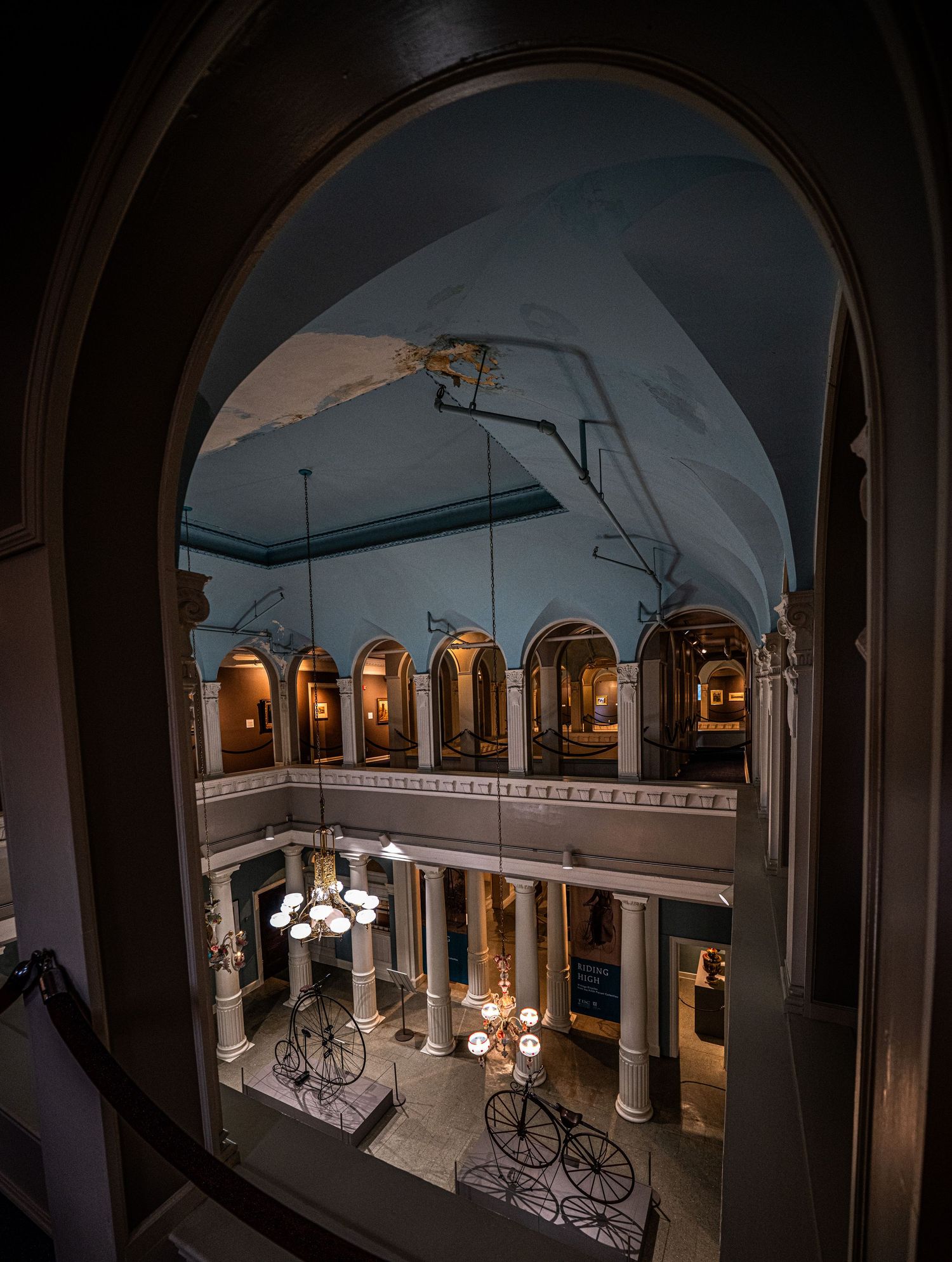 Vintage museum atrium with arched doorways, antique fixtures, and period furnishings.
