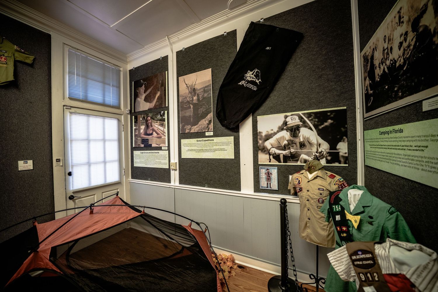 Museum exhibit space with historical displays and artifacts on dark walls.