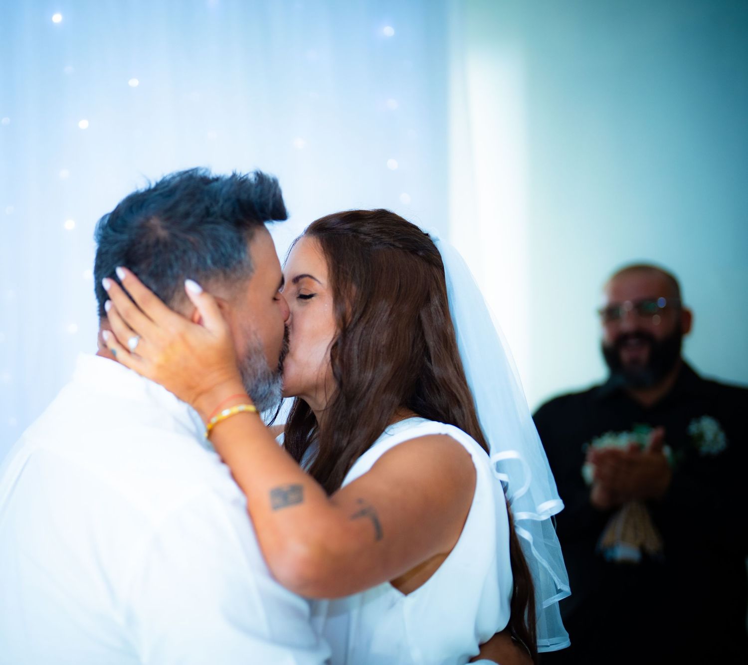 A romantic wedding sequence shows a couple sharing intimate kisses in a softly lit setting with a dreamy blue backdrop.