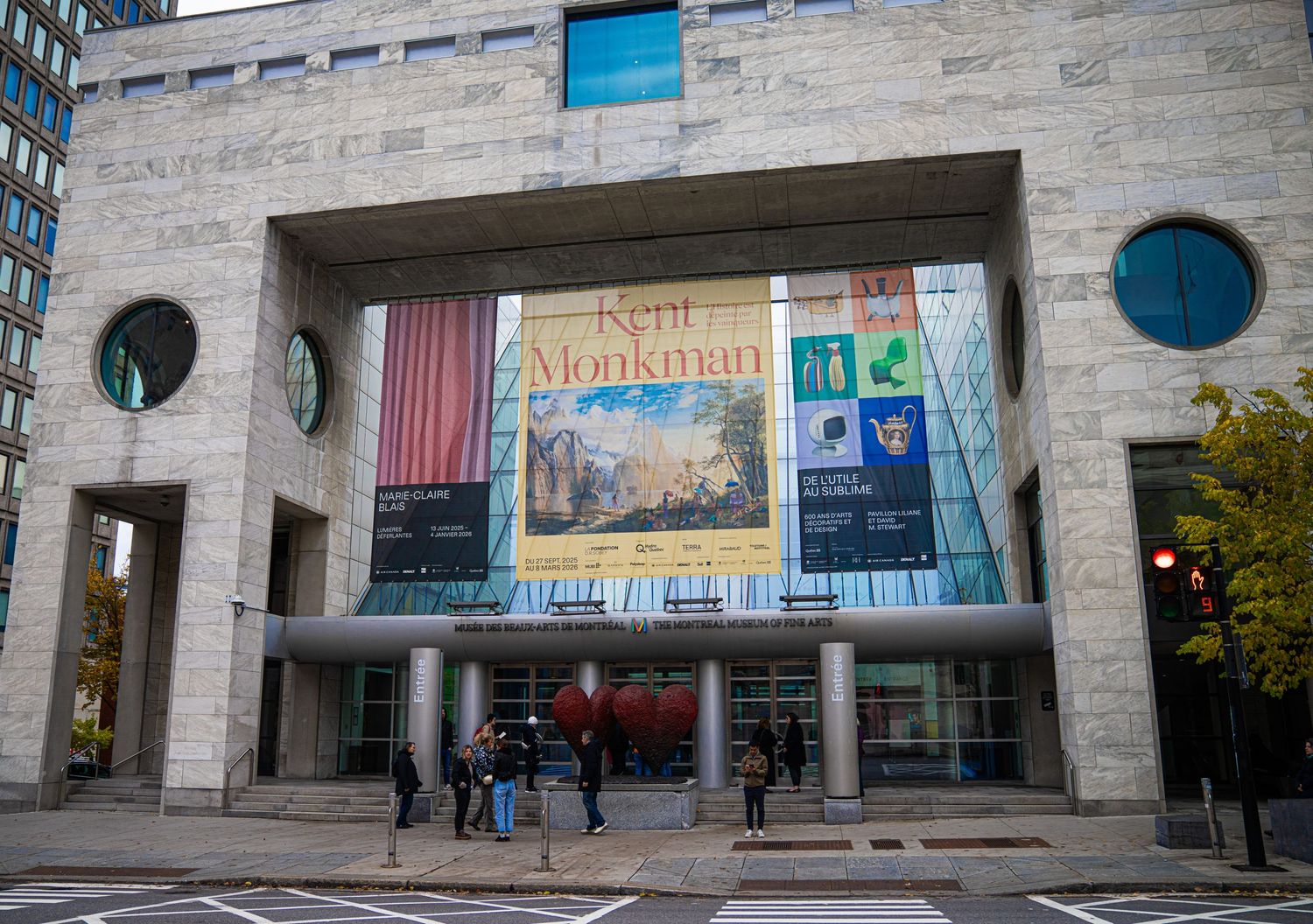 Modern concrete building exterior with glass windows and entrance displaying exhibition banners.