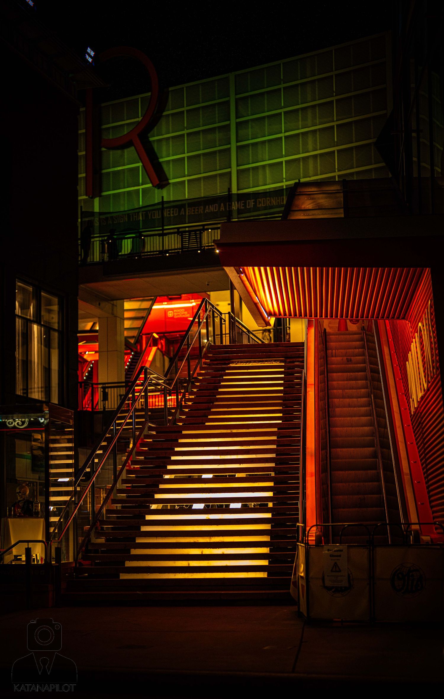 Illuminated wooden staircase in subway station at night with dramatic red lighting and shadows.