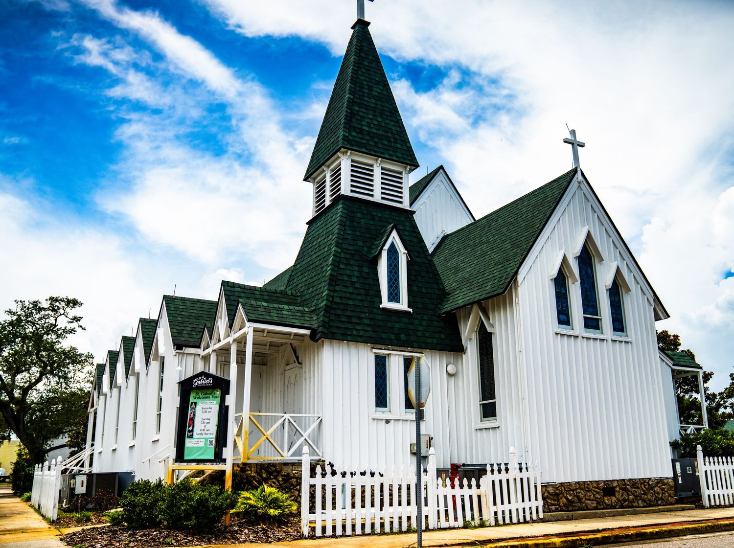 Row of white chapel-style buildings with pointed spires and picket fencing.