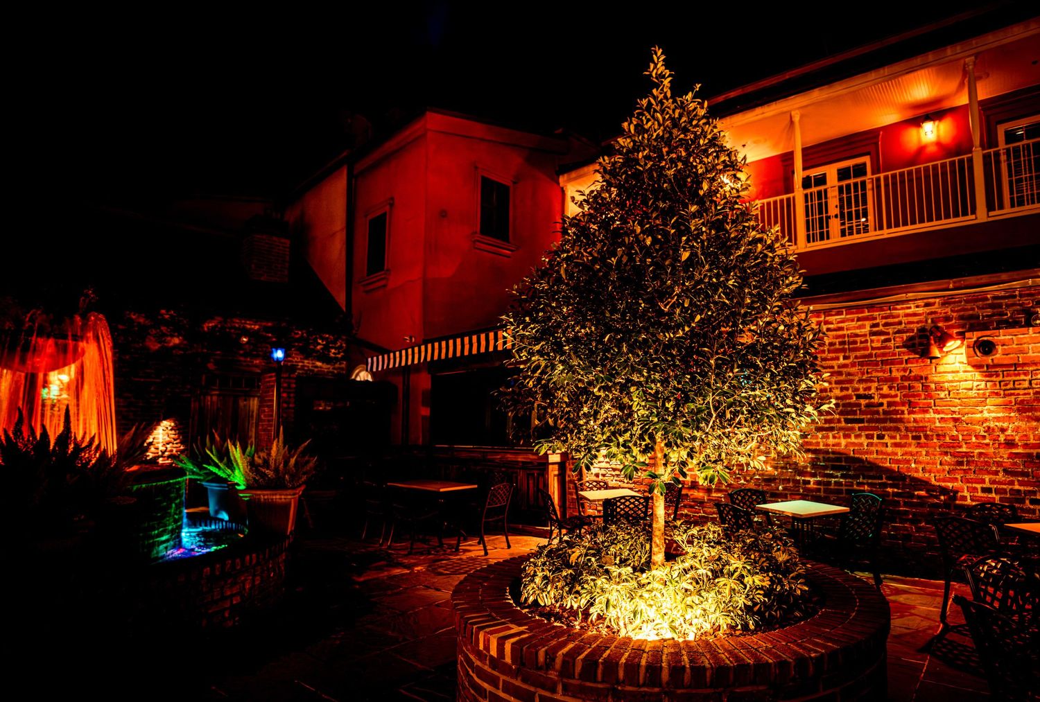 A series of outdoor holiday light displays illuminating homes and landscapes with warm red and golden glows at night.