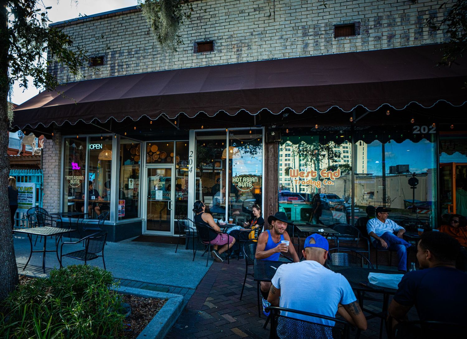 A series of connected images showing an outdoor shopping area with benches and storefronts at dusk.