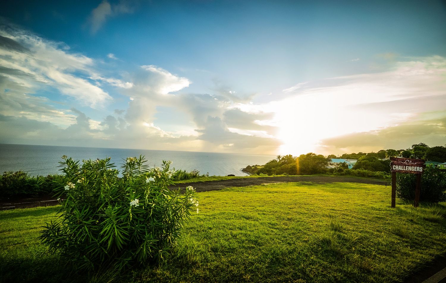 Rolling green hills and meadows at sunset with dramatic cloud formations in the sky.